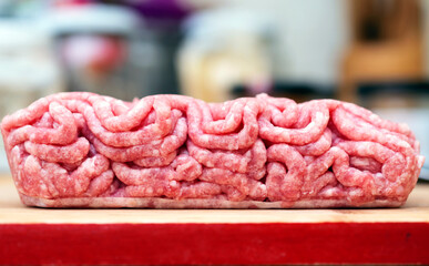 Red minced pork with beef meat on wooden board in the kitchen.