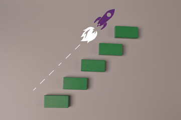 Wooden blocks with launching rocket. Business start up, new idea and new project concept.