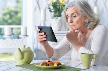 Obraz na płótnie Canvas Portrait of senior woman with tablet pc