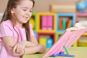 Cute little girl reading book