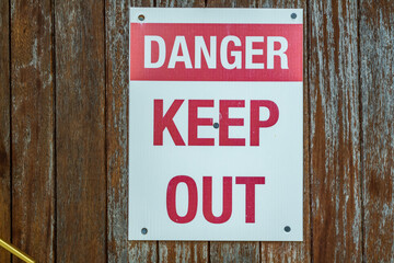 A red and white danger keep out sign attached to a door