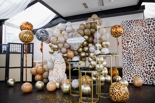 Moscow, Russia - May 2, 2021: Festively decorated photo zone in safari style. Balloon decor in gold, coffee, white and brown. Balloons with animal prints for children's birthday