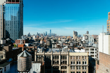 Skyline of Manhattan in New York City with water towers on the rooftops a sunny day with blue sky....