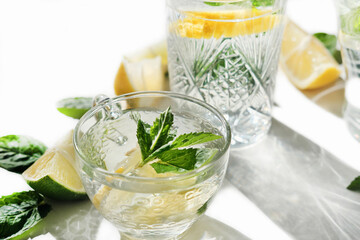 fresh lemon and mint drink in a glass cup. summer cold infused water for freshness. lime and lemon...