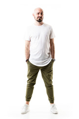 Distrustful expression of young bald man looking at camera with raised eyebrow. Full body length isolated on white background