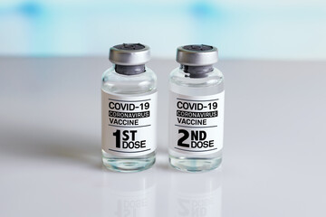 COVID-19 Vaccine Vials that require 2 injections tagged with 1st 2nd dose. Two bottles of...