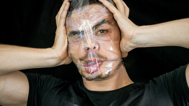 the movements he played with the mad man's face. eye with different looks and crazy head, in front of black background.