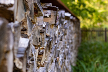 closeup of chopped firewood in green rural environment. Woodpile stacked and prepared for winter Pile of wood logs.