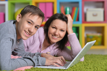 Excited mother and son with modern laptop