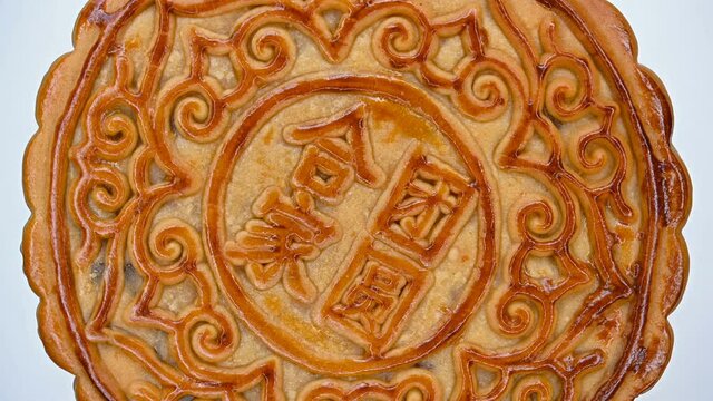 translation of the Chinese to English-family reunion-top view round and big traditional mooncake rotating