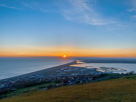sunset over the sea with harbour