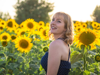 Mujer joven y guapa disfrutando de la primavera o verano en un campo de girasoles