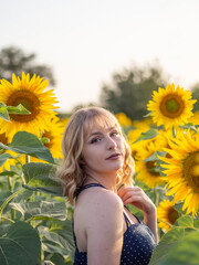 Mujer joven disfrutando de sus vacaciones de verano en un campo de girasoles