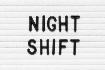 Black alphabet letter in word night shift on white felt board background