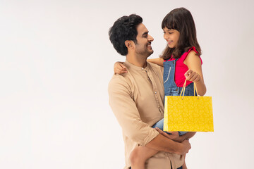 A FATHER AND DAUGHTER POSING WITH EACH OTHER AFTER SHOPPING	