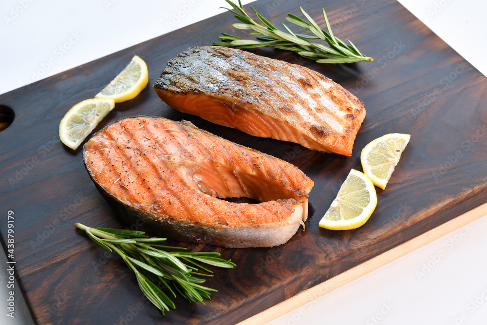 Wall mural Grilled salmon steaks with ingredients on wooden cutting board in the kitchen