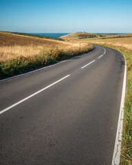 Country Road, Sussex, England. A curved road through the South Downs leading to the Belle Tout lighthouse overlooking the distant English Channel. - 438799177