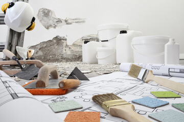 house renovation and plan concept. Plasterer tools, spatulas, brushes and samplers colors on blue...