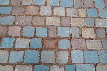 The background of the old textured cobblestone pavement
