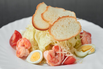 Gourmet caesar salad with shrimps and croutons.
