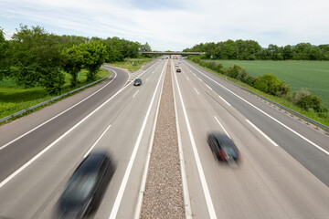 Blick von oben auf eine Autobahn mit schnell fahrenden Autos.