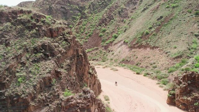 Drone shot of bicyclist ride in the desert canyon