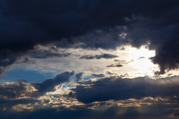Sun shining through dark clouds . Sunlight rays and cloudy heaven
