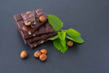 chocolate bars with hazelnuts, next to mint and hazelnuts