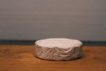 Cheese with white mold, close-up. A delicacy. Slicing a cheese plate. Italian or French brie or camembert cheese. Farm product made from natural cow's milk