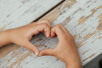 Hands of a child with a heart