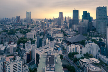 Tokyo, Japan - 12.05.2019: Dramatic yellow sunset under heavy grey clouds in the center of Tokyo on a warm spring evening viewed from Tokyo Tower observatory.