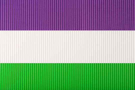 Official Genderqueer flag made of purple, white and green corrugated paper. Concept of genderqueer pride, agenderness, tolerance and respect for sexual minorities