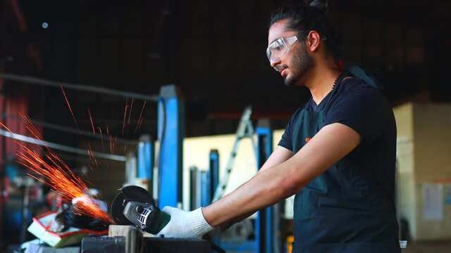 latin hispanic auto mechanic in uniform is examining a car while working in auto service