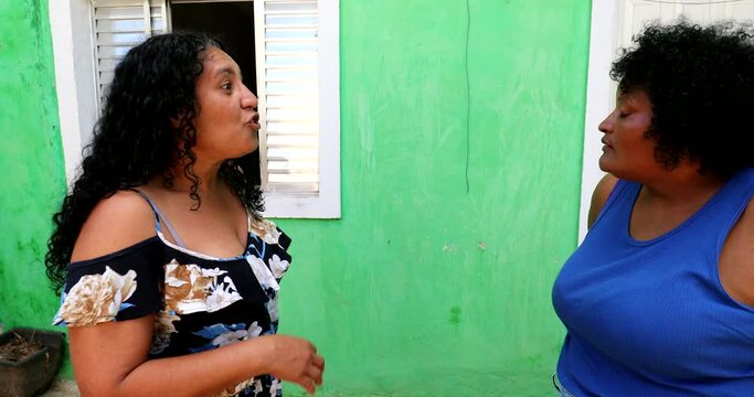 Two hispanic women gossiping and talking. Latinas expressive conversation