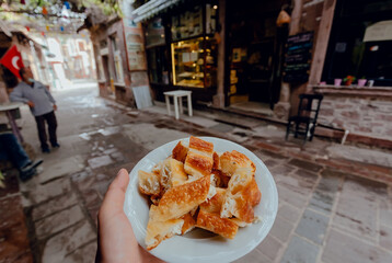 Breakfast with traditional turkish borek food on street with bars and local cafes. Turkish dish.