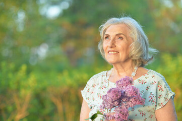 happy  senior beautiful woman with lilacs