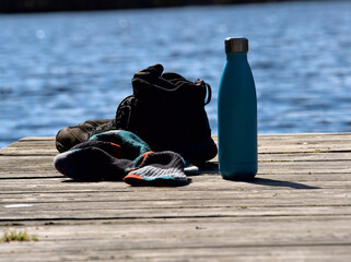 Trekking break on a pier, shoes and socks off, water in the bottle and relaxing