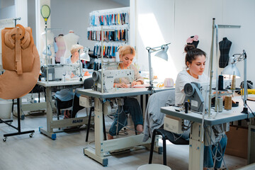 Russia Moscow 5 June 2021 Woman dressmaker, seamstress, modiste tailor working at the sewing behind...
