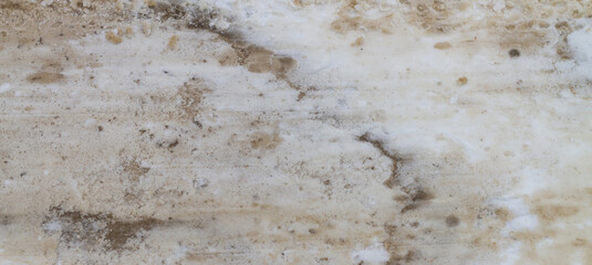The texture of dirty snow on the road leveled by a bulldozer bucket