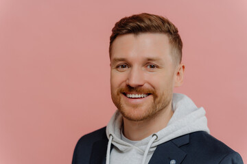 Young cheerful handsome man on pink background