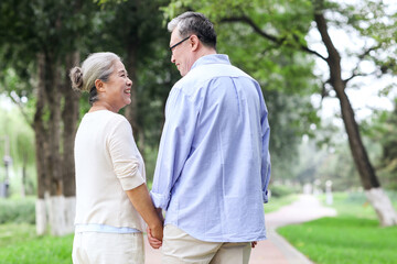 Obraz premium Happy old couple walking in the park