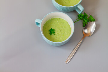 Green cabbage broccoli soup in plates decorated with parsley leaves