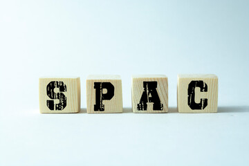 SPAC, special purpose acquisition company symbol. Wooden cubes with word 'SPAC' on beautiful white...