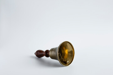 Obraz na płótnie Canvas The old-style hand bell with a wooden handle and probably a brass body was used as a break bell in schools. isolated