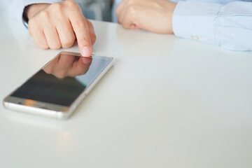 Smartphone Mobile phone hold touch in a Asian people hand in coffee shop restaurant waiting for friends with hand touching a Smart Phone, Technology smartphone communication Background Concept