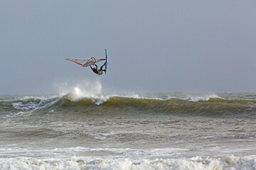 A windsurfer rides a wave and is airborne - UK