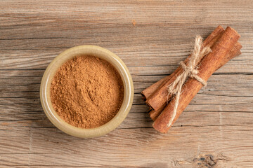 cinnamon sticks and powder on a wooden table with copy space