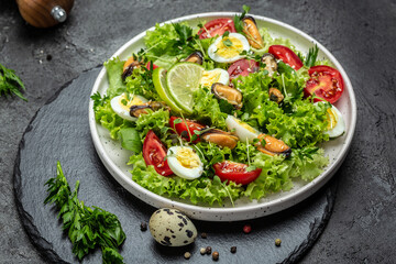 Healthy vegetable salad with mussels, mussels, quail, egg, conjugate, lime, spinach, lettuce, cherry tomatoes and microgreen. Diet menu. Top view