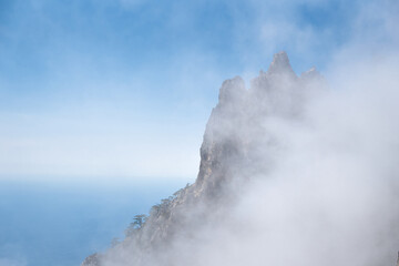 Clouds cover the rocky summit. Rocky Mountains.