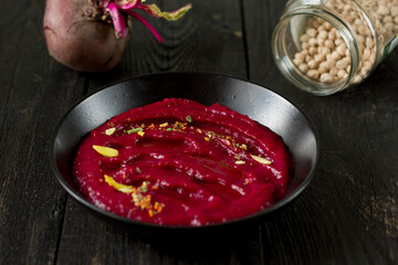 Delicious vegetarian beetroot hummus in a black plate